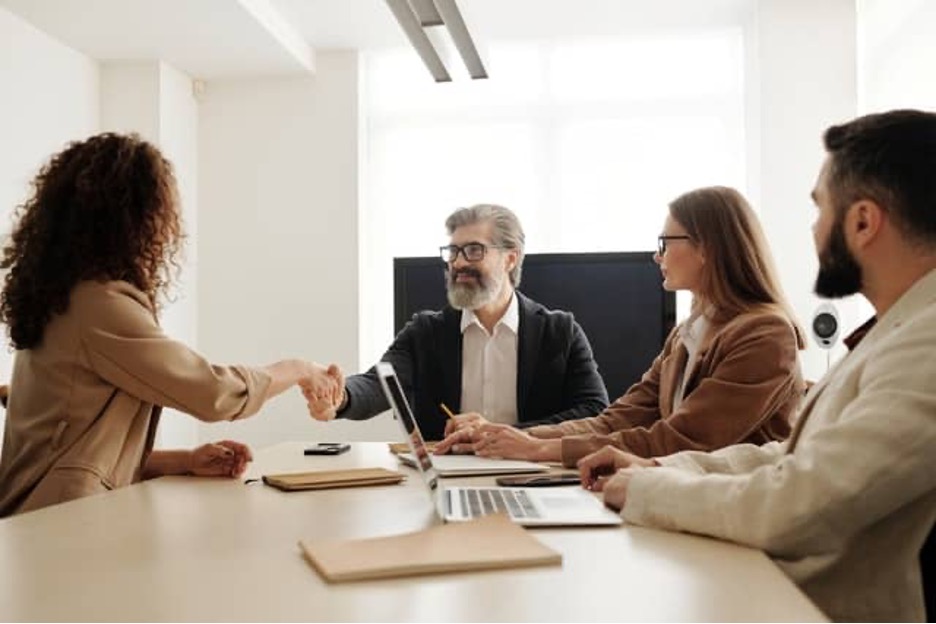 A newly hired employee shaking hands with her team leader